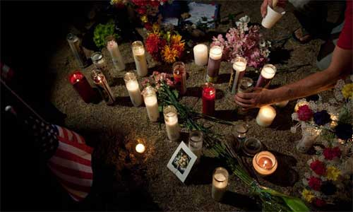 People light the candles to mourn for victims near a theater where a gunman opened fire at moviegoers in Aurora, Colorado, July 20, 2012. Twelve people were killed and 59 others injured at a Batman movie premier, where a lone, heavily armed gunman burst into a packed theater in a suburb 10 miles east of Denver during the wee hours of Friday. Local police identified the perpetrator to be James Holmes, 24, who was detained in the parking lot of the Century 16 Movie Theaters in Aurora shortly after the shooting spree. Photo: Xinhua