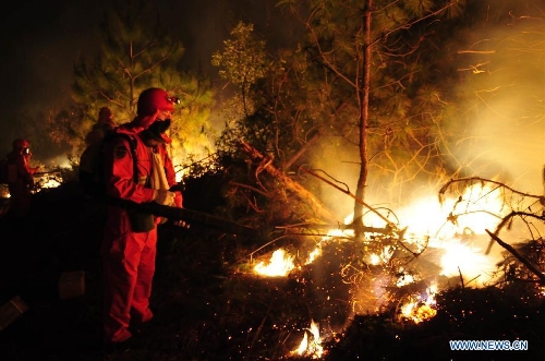Forest policemen try to put out a forest fire in Anning, southwest China's Yunnan Province, April 9, 2013. The fire broke out around 1 p.m. (0500 GMT) in Anning City. Forest policemen and firefighters have been mobilized to quench the fire. (Xinhua/Zhong Yaojun) 