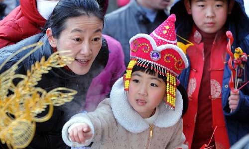 A girl (C) looks at a sugar sculpture at a temple fair celebrating Chinese Lunar New Year, or the Spring Festival, in Shenyang, capital of northeast China's Liaoning Province, Feb. 10, 2013. Various activities were held all over China on Sunday to celebrate the Spring Festival, marking the start of Chinese lunar Year of the snake. The Spring Festival falls on Feb. 10 this year. Photo: Xinhua