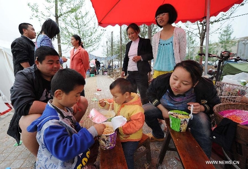 Residents have breakfast at a temporary shelter site in Luyang Township of Lushan County in Ya'an City, southwest China's Sichuan Province, April 21, 2013. Several temporary shelter sites can be seen in Lushan County and the life supplies in these shelter sites are sufficient. A 7.0-magnitude earthquake jolted Lushan County on April 20 morning. (Xinhua/Li Jian)