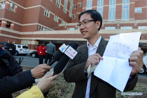 Chinese Vice Counselor-General Zhong Ruiming (R) of the Chinese Consulate General in New York shows words written by injured Chinese student Zhou Danling at the Boston Medical Center in Boston, the United States, April 16, 2013. The words read 