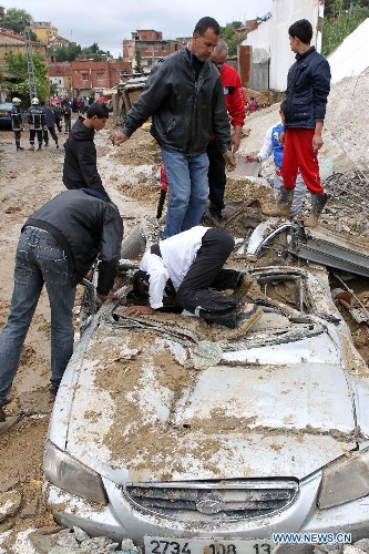 Local residents try to make the clearance of a car stuck in mud in Beni Messous suburb, in upper Algiers, Algeria, on May 22, 2013. Heavy rain poured since Tuesday in several provinces in northern part of the country, claiming the life of one citizen, injuring three others, and causing extensive damages. (Xinhua/Mohamed Kadri) 