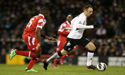 Fulham's Dimitar Berbatov (right) drives ahead of Queens Park Rangers' Nedum Onuoha on Monday. Photo: CFP