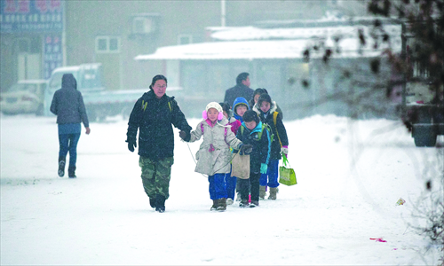Kids walk in the snow at Sun Village of Tianjin, in February 2012. Photo: CFP