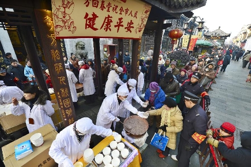  Citizens get free porridge at a Chinese herbal medicine store in Hangzhou, capital of east China's Zhejiang Province, Jan. 19, 2013, to celebrate the traditional Laba Festival. Laba literally means the eighth day of the 12th lunar month. The Laba Festival is regarded as a prelude to the Spring Festival, or Chinese Lunar New Year, the most important occasion of family reunion, which falls on Feb. 10 this year. Eating porridge is an old tradition on the Laba Festival in China. (Xinhua/Li Zhong) 
