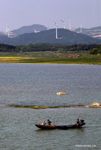 Photo taken on April 7, 2013 shows the Bijiashan Wind Power Plant beside the Poyang Lake in Jiujiang City, east China's Jiangxi Province. The Bijiashan Wind Power Plant, invested by China Power Investment Corporation, has been put into operation with 48 megawatts of installed generating capacity. Currently, there are five wind power plants around the Poyang Lake, respectively Jishanhu, Changling, Daling, Laoyemiao and Bijiashan. (Xinhua/Fu Jianbin) 