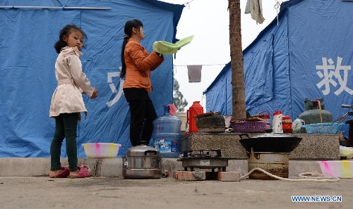 A woman and a youg girl wash their hands after getting up in the morning at a temporary settlement for quake-affected people in Lushan County, southwest China's Sichuan Province, April 23, 2013. A 7.0-magnitude earthquake jolted Lushan County on April 20, leaving at least 192 people dead and 23 missing. More than 11,000 people were injured. (Xinhua/Li Gang)  