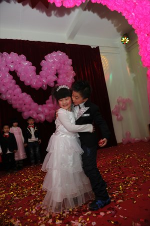 Children hug and kiss in a mock mass wedding at a kindergarten in Zhengzhou, Henan Province on Friday. 
Photo: CFP