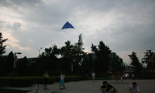 Main: A kite monitoring air quality flies over Deshengmen. 