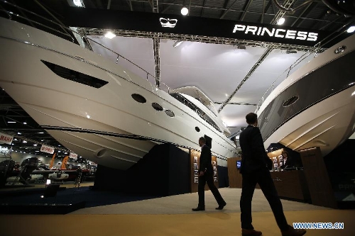 Visitors pass by boats at the 58th London Boat Show, held at the ExCeL Exhibition and Convention Centre in London, Jan. 14, 2013. The 58th London Boat Show showcases, demonstrates and sells maritime equipments including luxury yachts, dinghies, boating equipment and clothing with interactive sections and features attractions devoted to boating until Jan. 20, 2013. (Xinhua/Wang Lili) 