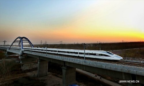 A train runs through the Yellow River Rail-Road Bridge in Zhengzhou City, capital of central China's Henan Province, November 25, 2012. The high-speed rail route from Beijing to the southern Chinese city of Guangzhou will open next month, cutting the 2,200-km journey time by 14 hours, according to the Ministry of Railways. A trial operation along the Beijing-Zhengzhou section, the last part of the route, began on Sunday morning. Photo: Xinhua