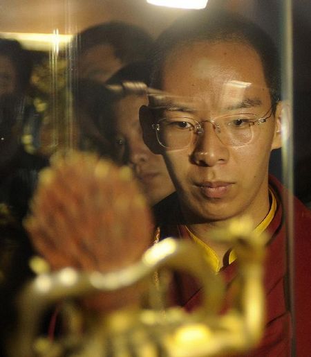 The 11th Panchen Lama Bainqen Erdini Qoigyijabu (front) views a Buddha statue during an exhibition of Tibet cultural relics returned from overseas in Tibet Museum in Lhasa, capital of Southwest China's Tibet Autonomous Region, July 28, 2012. Photo: Xinhua