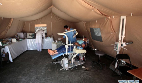 A Syrian refugee receives medical care at a Moroccan military field hospital in the Zaatari camp for Syrian refugees, 15 kilometres (nine miles) from the kingdom's northern city of Mafraq, near the border with Syria, on August 11, 2012. There are now about 3,000 Syrians taking shelters in the desert Zaatari refugee camp that was opened last month to alleviate the humanitarian crisis. Photo: Xinhua