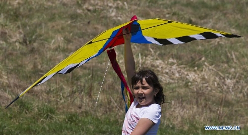 A girl is ready to fly a kite during the 24th Annual Four Winds Kite Festival at the Kortright Centre for Conservation in Toronto, Canada, May 4, 2013. (Xinhua/Zou Zheng)