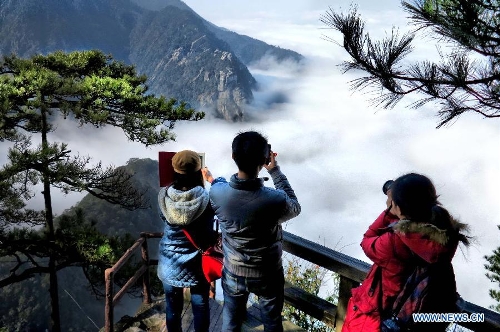  Tourists take photos at Shimenjian scenic spot on Lushan Mountain in Jiujiang, east China's Jiangxi Province, Feb. 22, 2013. (Xinhua/Qin Yongyan)  