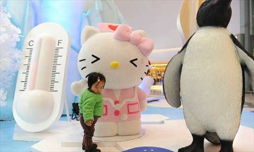 A little girl plays around a pink Hello Kitty in the Joy City in east China's Shanghai Municipality, Nov. 26, 2012. A big Hello Kitty exhibition themed on Hello Kitty's exploration in the polar regions would last from Nov. 24, 2012 to Feb. 24, 2013 in Shanghai. Photo: Xinhua