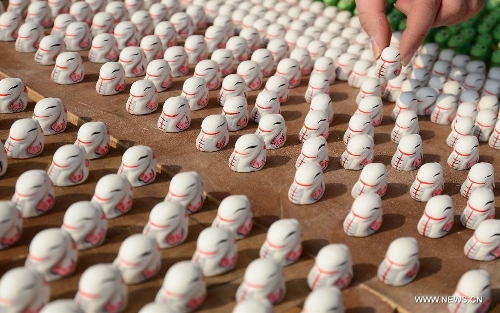 An artisan makes the traditional Chinese clay sculptures in shape of snake in Wuxi City, east China's Jiangsu Province, Jan. 8, 2013. The lunar year 2013 is the 
