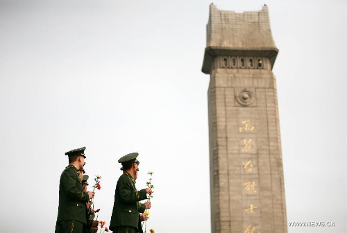 Soldiers present flowers at a monument during a memorial ceremony held at Yuhuatai Martyr Cemetery in Nanjing, capital of east China's Jiangsu Province, March 30, 2013. Various memorial ceremonies were held across the country to pay respect to martyrs ahead of the Qingming Festival, or Tomb Sweeping Day, which falls on April 4 this year. (Xinhua) 