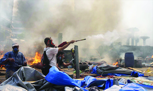 A supporter of the Muslim Brotherhood and Egypt's ousted president Mohamed Morsi fires fireworks toward police during clashes in Cairo on Wednesday, as security forces backed by bulldozers moved in on two huge pro-Morsi protest camps, launching a long-threatened crackdown. Photo: AFP