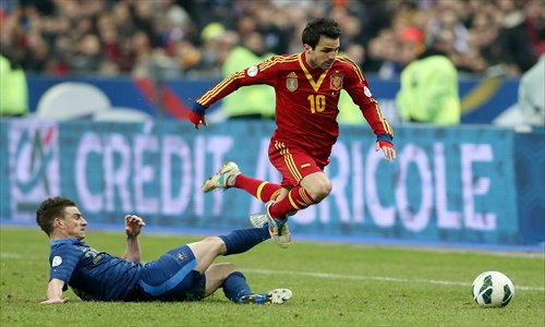 Francesc Fabregas (No.10) of Spain is brought down by Laurent Koscielny of France on Tuesday. Photo: CFP