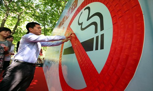 A man signs his name at an anti-smoking campaign event. Photo: CFP