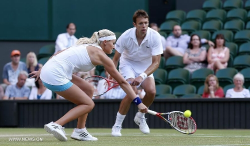 Daniel Nestor of Canada and Kristina Mladenovic (L) of France compete during the final of mixed doubles against Bruno Soares of Brazil and Lisa Raymond of the United States on day 13 of the Wimbledon Lawn Tennis Championships at the All England Lawn Tennis and Croquet Club in London, Britain, on July 7, 2013. Daniel Nestor and Kristina Mladenovic claimed the title with 2-1. (Xinhua/Wang Lili) 