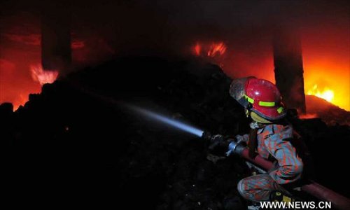 A firefighter tries to control a fire at a garment factory located on the outskirt of Bangladeshi capital Dhaka on November 24, 2012.