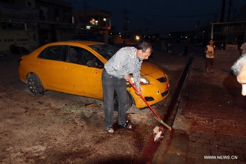 People clean the blast site at a Shiite mosque in Kirkuk, northern Iraq, May 16, 2013. At least 12 people were killed and 25 others injured as a suicide bomber blew himself up at a Shiite mosque in northern Iraq's Kirkuk on Thursday, local police sources said. (Xinhua/Dena Assad) 