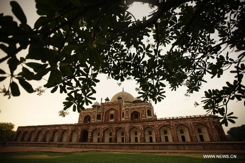 Photo taken on May 12, 2013 shows Humayun's Tomb at dusk in New Delhi, capital of India. Humayun's Tomb, located in east New Delhi, was built in 1569 to 1570 by Humayun's widow. As a precursor to the Taj Mahal, it stands on a platform of 12,000 square meters and reaches a height of 47 meters. The earliest example of the Persian influence in Indian architecture, the tomb itself is in the center of a large garden, surrounded by 12 hectares of gardens with pools joined by channels. The tomb brought Persian style to Delhi, but the two-tone combination of red sandstone and white marble is local, which shows the merging of different cultures. Humayun's Tomb was inscribed on the World Heritage List by the United Nations Educational, Scientific and Cultural Organization in 1993. (Xinhua/Zheng Huansong) 
