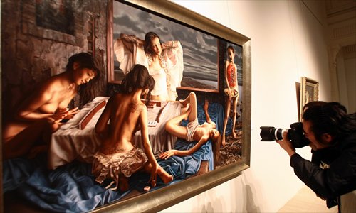A visitor takes a snapshot of Lui Liu's 2005 oil painting Beijing 2008 at an exhibition in Shanghai early this year. Photo:IC
