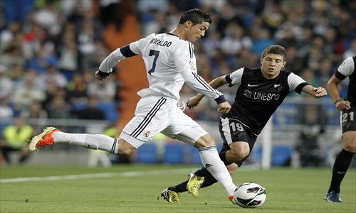 Real Madrid's Cristiano Ronaldo (No.7) passes against Malaga's Francisco Portillo on Wednesday. Photo: IC 