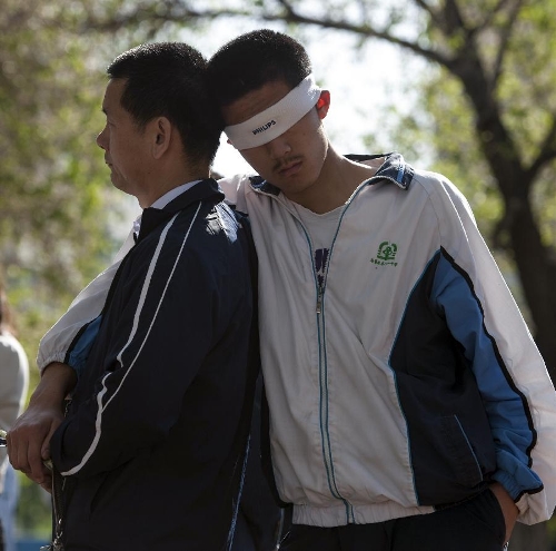 A boy and his father participate in activities during their coming-of-age ceremony at Bayi Middle School in Urumqi, capital of northwest China's Xinjiang Uygur Autonomous Region, May 7, 2013. More than 800 senior high school students in Bayi Middle School attended their coming-of-age ceremony on Tuesday. (Xinhua/Jiang Wenyao) 