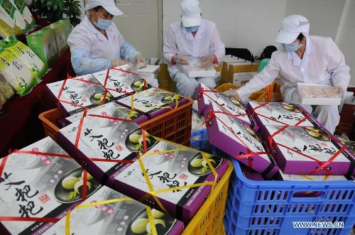 Workers package Ciba, a glutinous rice cake, in Shangsi County of Fangchenggang, south China's Guangxi Zhuang Autonomous Region, Jan. 30, 2013. As the spring festival drew near, people began their shopping for the celebration. (Xinhua/Liang Fuying) 