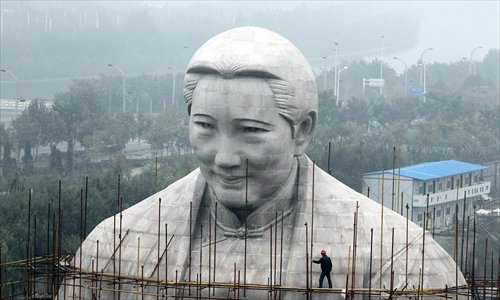 Workers tear down the half-finished statue of Soong Ching-ling, Sun Yat -sen's wife, in Zhengzhou, Henan Province. The 27-meter-tall statue allegedly cost 120 million yuan ($19.5 million) provided by the Henan Soong Ching-ling foundation. No explanation has been offered for the demolition. Photo: CFP