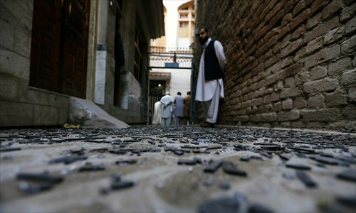 People inspect the scene of a bomb blast in Peshawar, Pakistan, on Wednesday. At least two persons were injured when a bomb planted on a street exploded in Peshawar. Photo: CFP