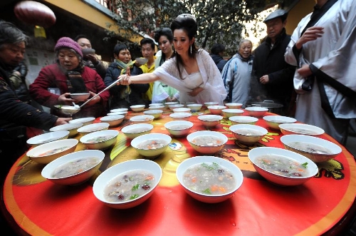  Citizens get porridge distributed by a performer acting as Madame White Snake, a white snake taking on a woman's form in a Chinese folk tale, at the Xuanzang Temple in Nanjing, capital of east China's Jiangsu Province, Jan. 19, 2013, to celebrate the traditional Laba Festival. Laba literally means the eighth day of the 12th lunar month. The Laba Festival is regarded as a prelude to the Spring Festival, or Chinese Lunar New Year, the most important occasion of family reunion, which falls on Feb. 10 this year. Eating porridge is an old tradition on the Laba Festival in China. Many temples also have the tradition of offering porridge to the public to commemorate Buddha and deliver his blessings to both believers and non-believers. (Xinhua/Sun Can) 