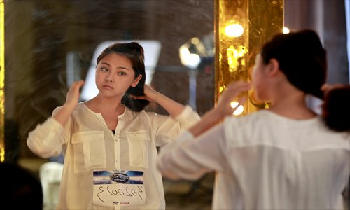 Cai Yingxuan checks herself in a dressing room mirror before going on stage. Photo: Yang Hui/GT