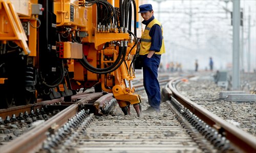  A worker inspects a railway line in Dehui, Jilin Province on May 12. The 900-kilometer high-speed line linking Harbin and Dalian in Northeast China is expected to start operation on July 1. Photo: CFP