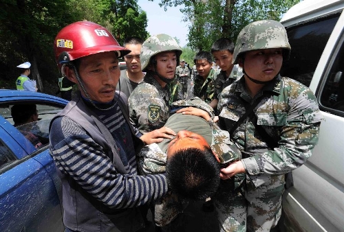 Rescuers carry out a soldier saved from a rescue car from Chengdu Military Region which falls off a cliff into a river in southwest China's Sichuan Province, April 20, 2013. Two of the 17 soldiers in the car have died by 11:30 p.m. Saturday Beijing Time. A total of 156 people have been killed in the 7.0-magnitude earthquake in Sichuan's Lushan as of 8:50 p.m. Saturday, according to the China Earthquake Administration. (Xinhua)  