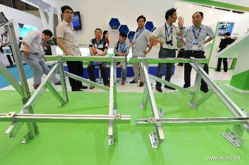 Visitors watch the photovoltaic products during the 2013 international photovoltaic exhibition in east China's Shanghai Municipality, May 14, 2013. The four-day exhibition, with the participation of more than 1,500 exhibitors, opened here Tuesday. (Xinhua/Lai Xinlin) 