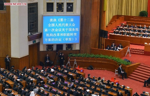  Deputies vote on a draft resolution on the plan of institutional reform and functional transformation of the State Council during the fourth plenary meeting of the first session of the 12th National People's Congress (NPC) at the Great Hall of the People in Beijing, capital of China, March 14, 2013. Chairman, vice-chairpersons, secretary-general and members of the 12th NPC Standing Committee, president and vice-president of the state, and chairman of the Central Military Commission of the People's Republic of China will also be elected here on Thursday. (Xinhua/Wang Song)