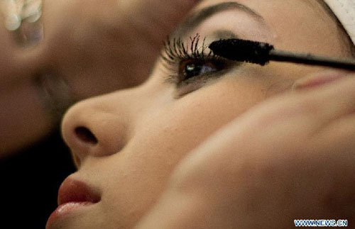 A 15-year-old girl gets her make-up done as she gets ready to participate in the mass Quinceanera Party, in Mexico City, capital of Mexico, April 28, 2012. The Quinceanera Party is a Mexican tradition marking the transition from childhood to adulthood. A massive party was organized in Mexico City Saturday to celebrate Quinceanera for girls with limited economic resources. Photo: Xinhua
