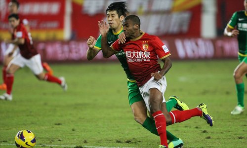 Muriqui (front) of Guangzhou Evergrande competes for the ball with Lang Zheng of Beijing Guoan in Guangzhou on Wednesday. Photo: CFP