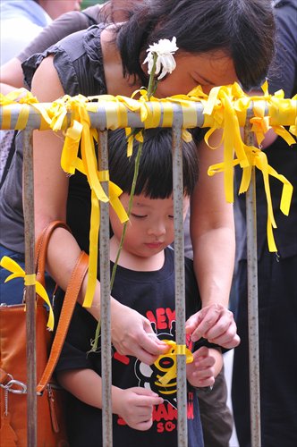 A boy in Hong Kong makes a tie to mourn eight compatriots who died in the Manila hostage incident on August 29, 2010. Photo: CFP