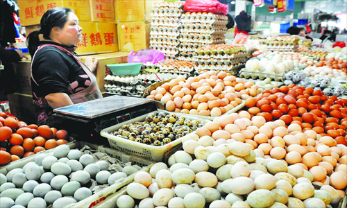 A vendor stands inside her egg booth at a farmers' market in Yiwu, East China's Zhejiang Province on Monday. Businesses selling live poultry and eggs have suffered in the province recently, ever since the H7N9 bird flu strain broke out at the end of March. Many poultry and egg vendors have been forced to close. In comparison, local sales of vegetables and seafood have seen a big jump in the wake of the bird flu outbreak. Photo: IC