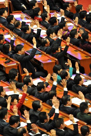 Delegates at the 18th CPC National Congress raise their hands to show consent at the closing ceremony of the congress on November 14, 2012. Photo: IC