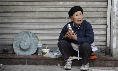 Zhang Huanian, a 76-year-old resident of Lushan county, sits and listens to news updates about earthquake relief efforts on a transistor radio April 25. Photo: Li Hao/GT