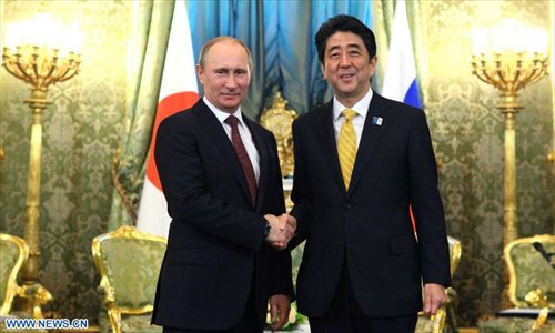 Russian President Vladimir Putin (L) shakes hands with visiting Japanese Prime Minister Shinzo Abe in Moscow, Russia, on April 29, 2013. (Xinhua/RIA Novosti) 