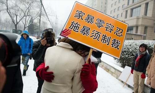Kim Lee embraces a supporter holding a sign which reads “zero tolerance for domestic abuse, violence must be punished” outside the Beijing Chaoyang District Court on February 3. Photo: Li Hao/GT
