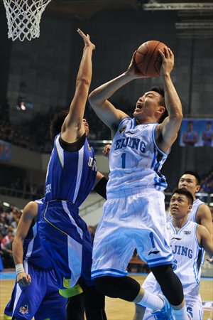 Beijing Ducks' Li Gen drives against a Jiangsu Dragons player during their Chinese Basketball Association match in Beijing on Wednesday. Beijing garnered their fourth straight win since the start of the season with 114-107. Photo: CFP